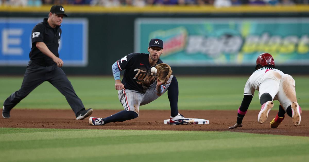 Ryan Kreidler of the Minnesota Twins fields the ball as Geraldo Perdomo of the Arizona Diamondbacks tries to steal second base during the seventh inning of the MLB game at Chase Field on Sunday, June 21, 2026, in Phoenix.
