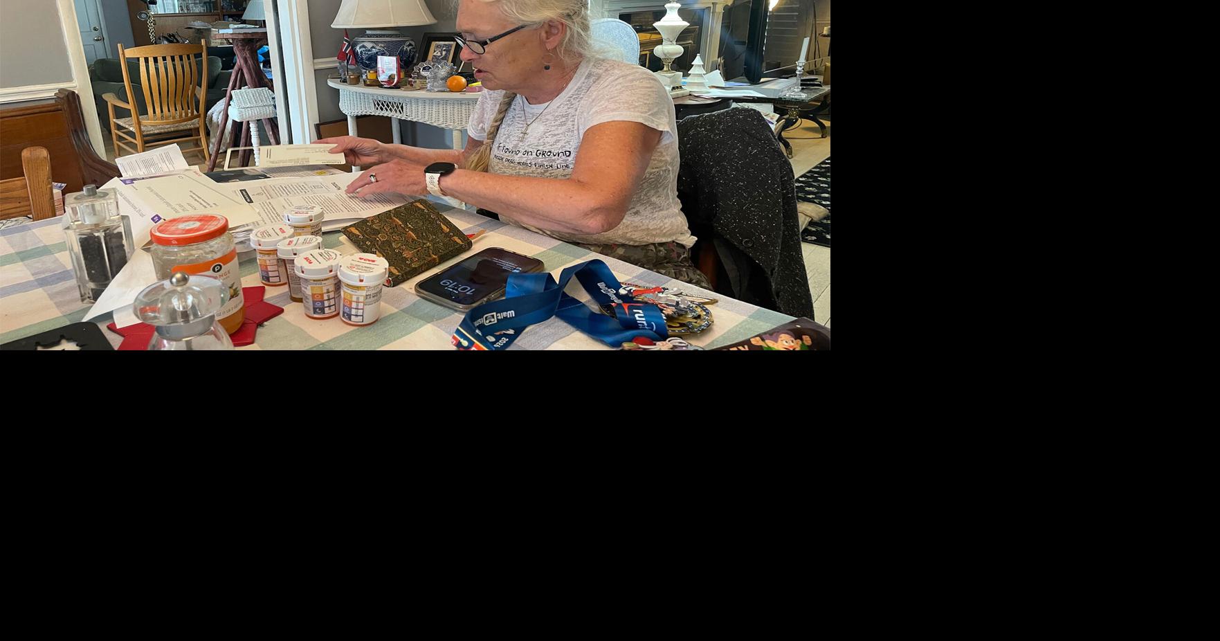 Margaret Hvatum of suburban St. Louis sorts through letters she has received from Humana. She missed several weekly doses of a medicine to treat a chronic condition after her Humana Medicare Advantage plan denied payment for the drug. **KFF Health News provided photos must include credit/caption and can only be used with the original KFF Health News story**.