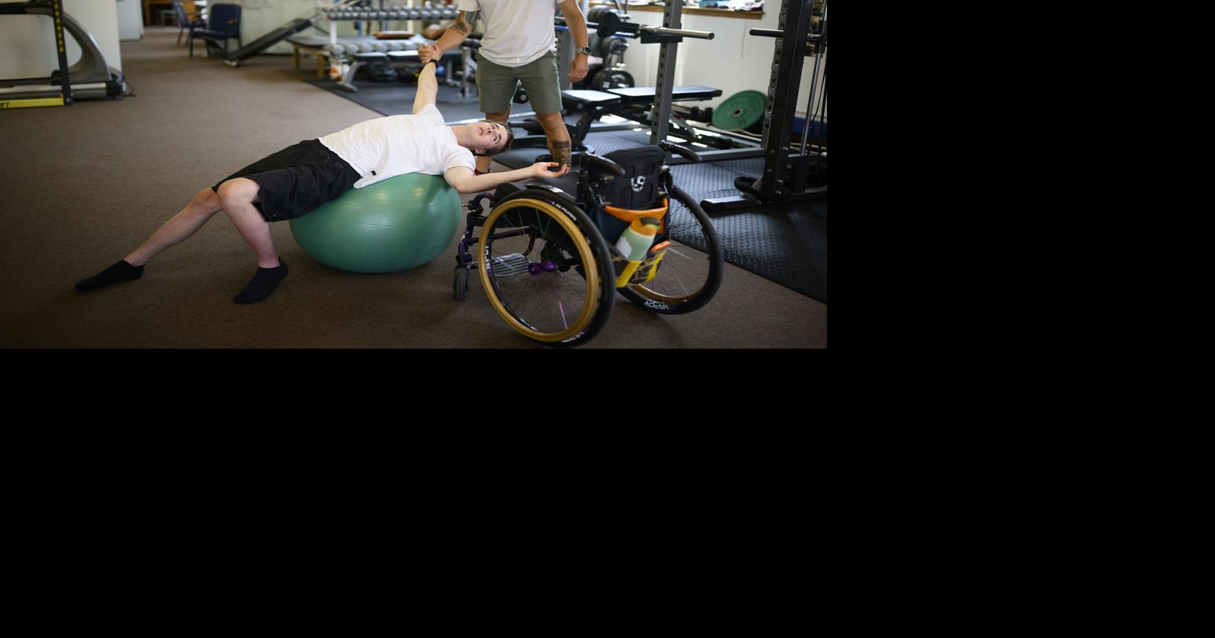 Mason Branstrator and his trainer, Blake Peters, use a yoga ball to release tension through Branstrator’ s lower back at the end of a session Wednesday, July 29, 2026, in Duluth, Minn..