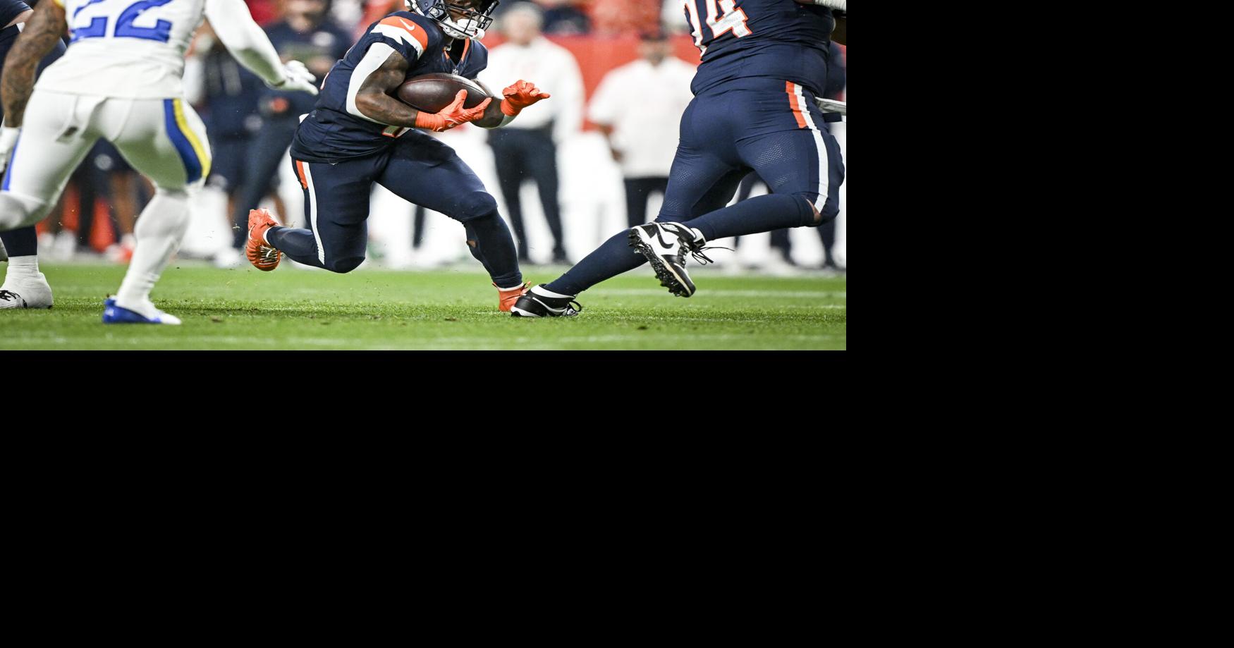 RJ Harvey of the Denver Broncos runs as Trent McDuffie of the Los Angeles Rams pursues him during the first quarter at Empower Field at Mile High in Denver on Sunday, Sept. 27, 2026.