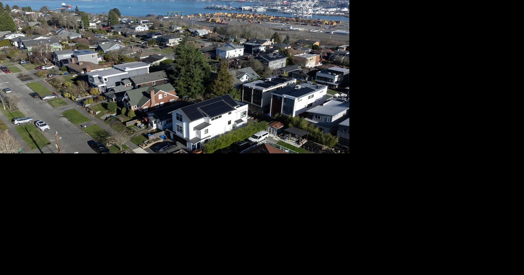 The downtown skyline is seen behind rows of houses in West Seattle on Sunday, Jan. 18, 2026.