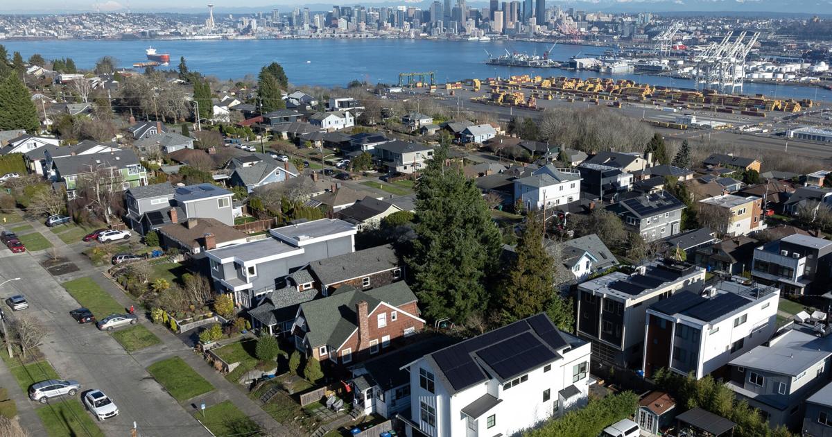 The downtown skyline is seen behind rows of houses in West Seattle on Sunday, Jan. 18, 2026.