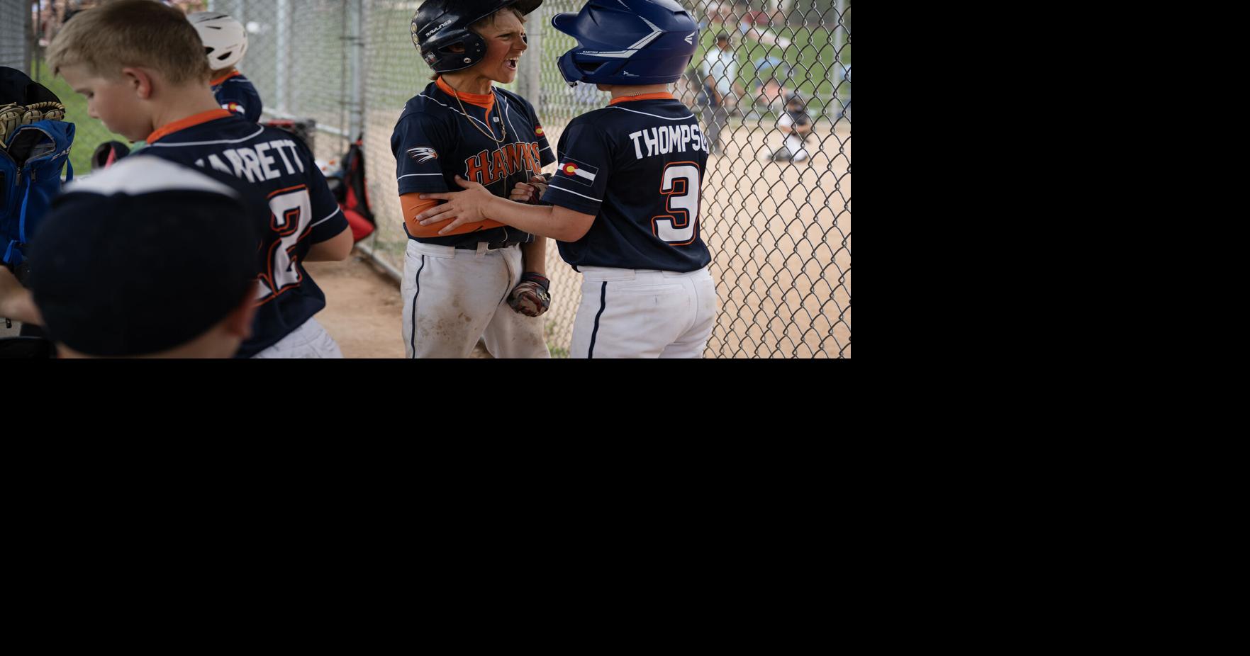 Parker Hawks Orange players Jax Newman and Jonah Dusing celebrate scoring in a 10 U AA youth baseball tournament game against the Parker Hawks White on Saturday, June 20, 2026, at Evans Park in Elizabeth, Colo..