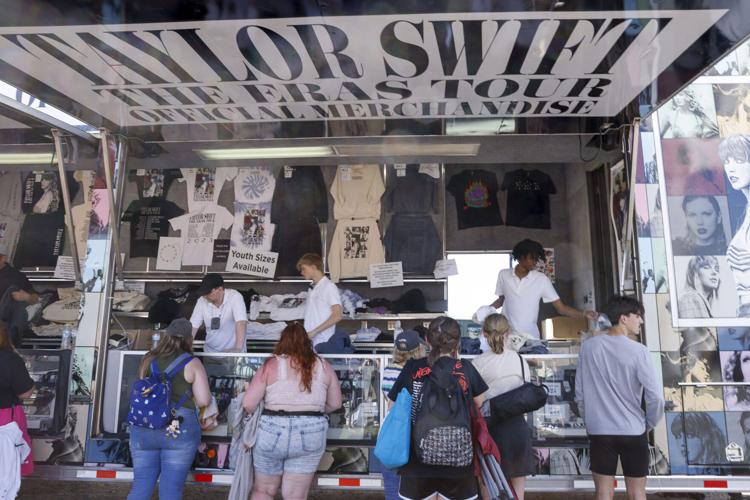 Fans buy merchandise before a Taylor Swift Eras Tour concert at AT&T Stadium in Arlington, Texas.