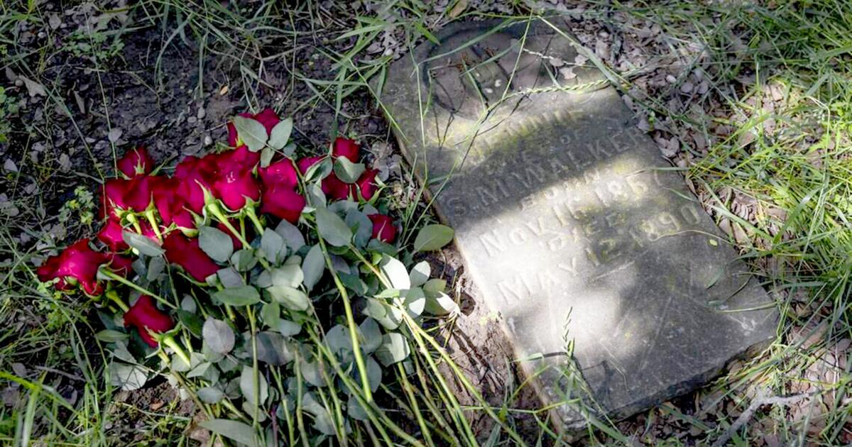 The St. John's Cemetery Association lays roses near a grave to remember those who are buried at the cemetery on Saturday, May 9, 2026 in Denton, Texas.