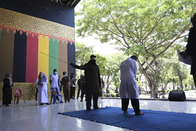 Men charged with hugging and kissing are among group publicly caned by Indonesian Islamic court
