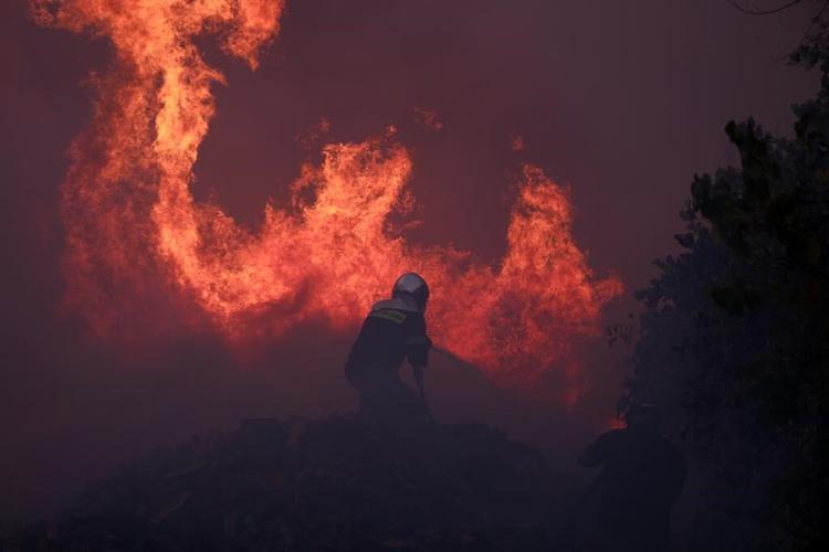 Hundreds of Greek firefighters battle a wildfire raging out of control on the fringes of Athens