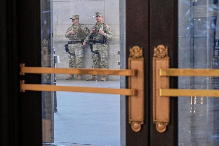 Photos of week three of Washington's federal takeover, as troops on patrol start carrying guns