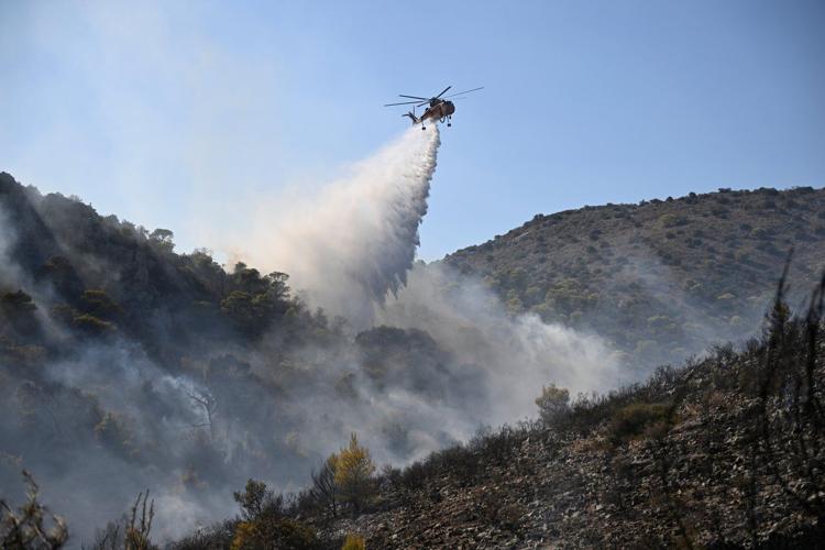 Firefighters battle massive wildfires in Belgium and Greece as 2 die on an island near Athens