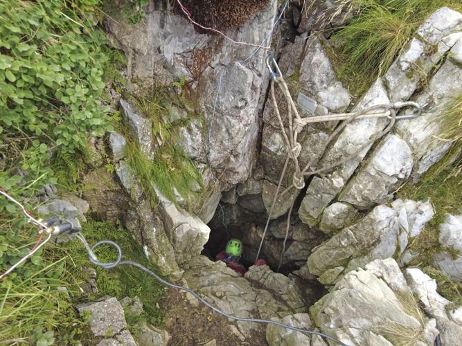 Rescuers work to free an injured cave explorer trapped more than 130 feet underground in Italy