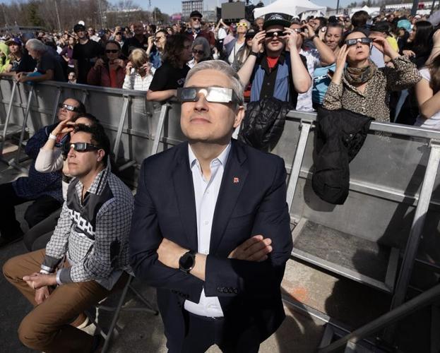 MPs clad in eclipse glasses stare at 'surreal' celestial event on Parliament Hill