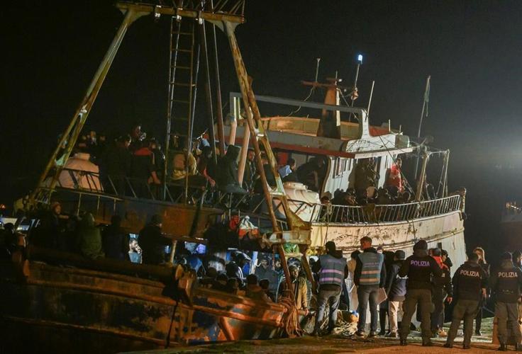 Italy's coast guard, navy, bring hundreds of migrants ashore