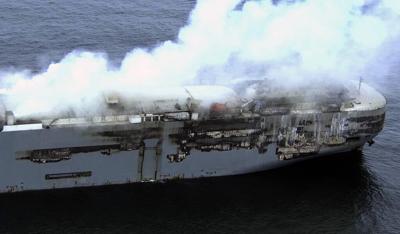 Salvage crews begin towing a burning cargo ship to a new location off the Dutch coast as smoke eases
