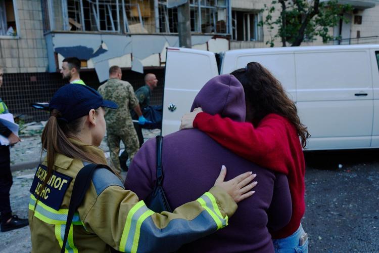 Photos show Kyiv residents clutching pets, collecting bodies after Russian missile and drone attack