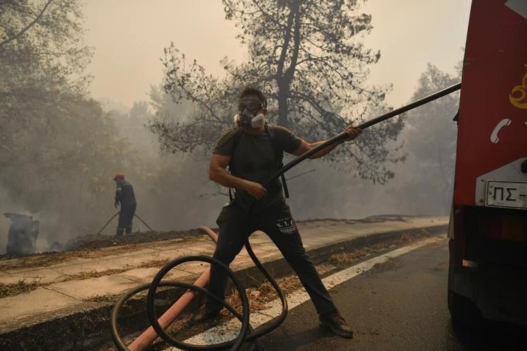 Hundreds of firefighters battle a major wildfire raging out of control on fringes of Greek capital