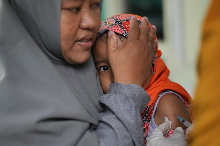 Photos show the efforts to curb a measles outbreak in Indonesia