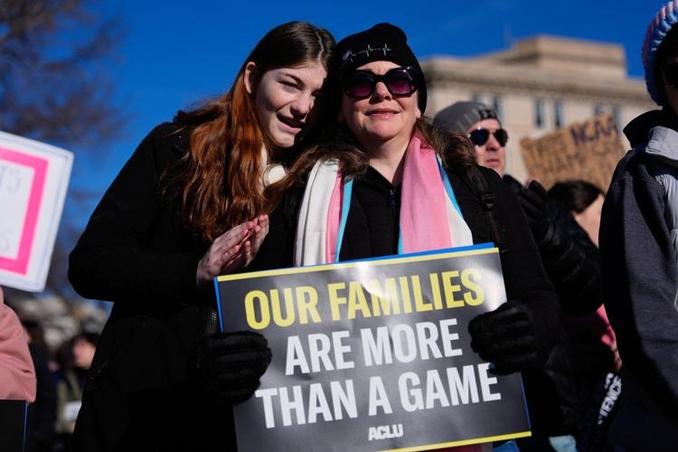 Photos of demonstrators outside the Supreme Court as it considers upholding transgender sports bans