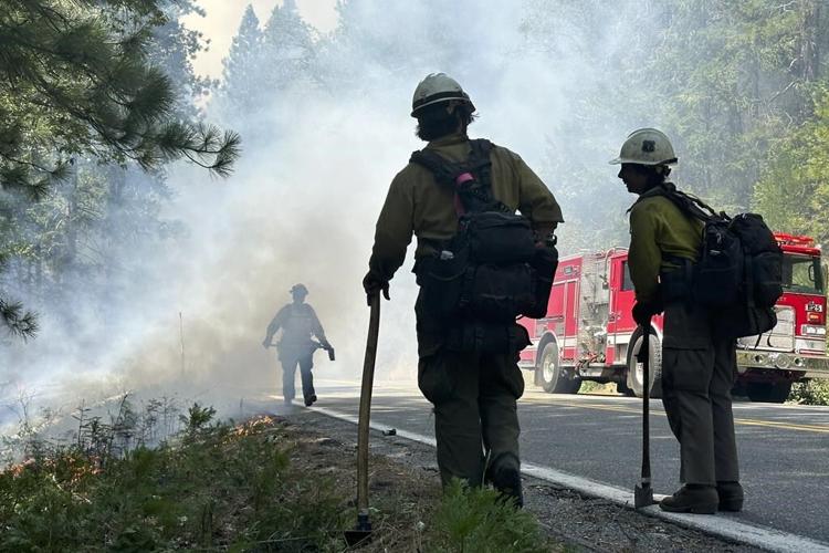 Crews battle wildfires across the US West and fight to hold containment lines