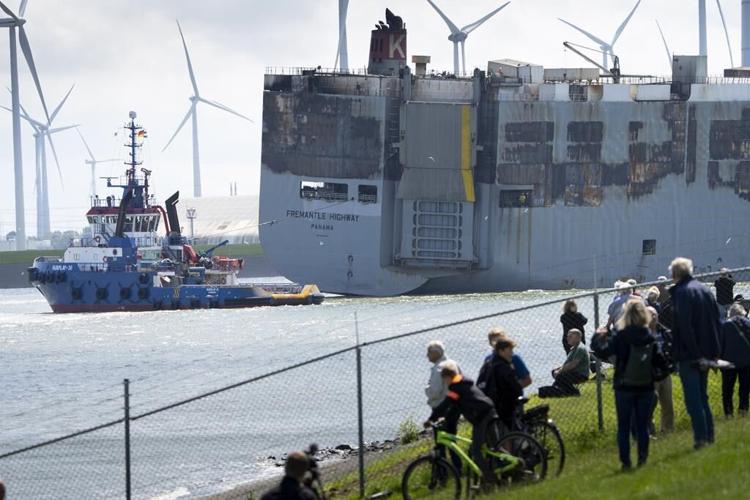 A car-carrying ship that burned for a week on the North Sea is towed to a Dutch port for salvaging