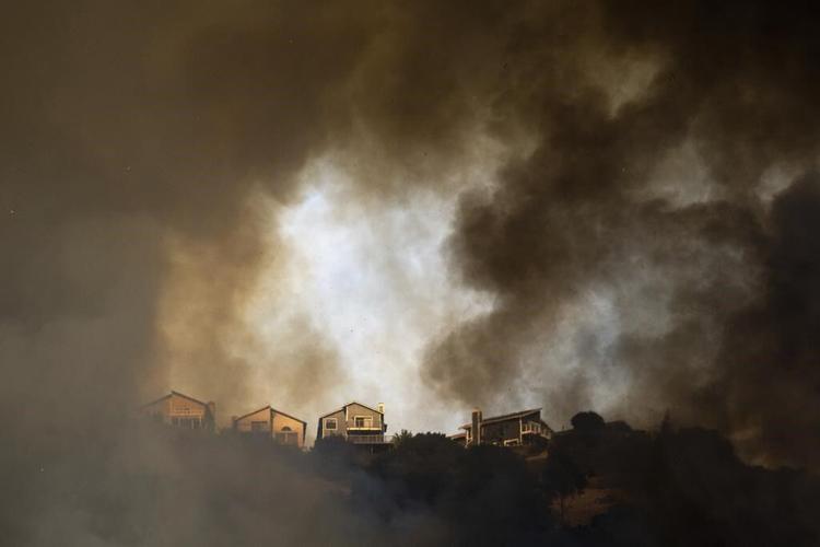 A fast-moving brush fire in California burned 2 homes while others were damaged by smoke and water