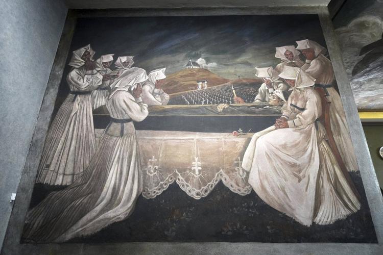 Inside a historic church painted with murals that reflect searing social commentary