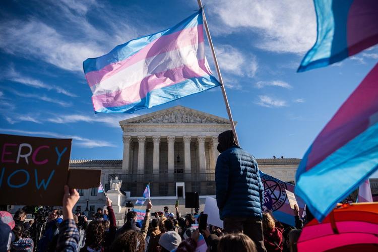 Photos of demonstrators outside the Supreme Court as it considers upholding transgender sports bans