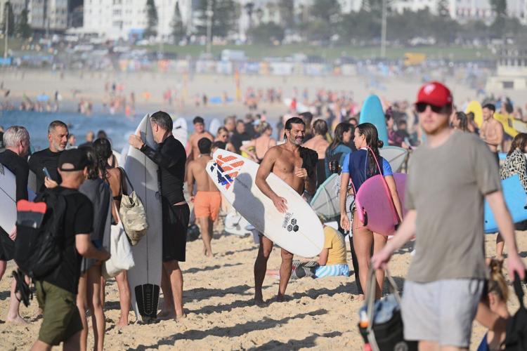 A sunrise crowd gathers at Bondi Beach in solace and defiance after a massacre