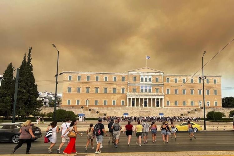 A wildfire near Greece's capital darkens the skies over Athens and advances fast