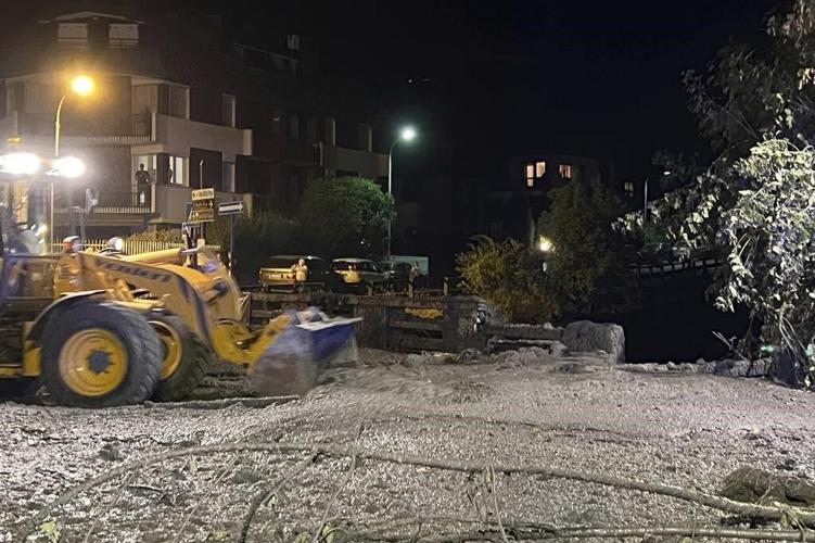 Crews search for possible missing after a mudslide in the Italian Alps coats city streets in muck