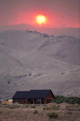 Dangerous weather hampers firefighters and leads to fireworks bans in western US
