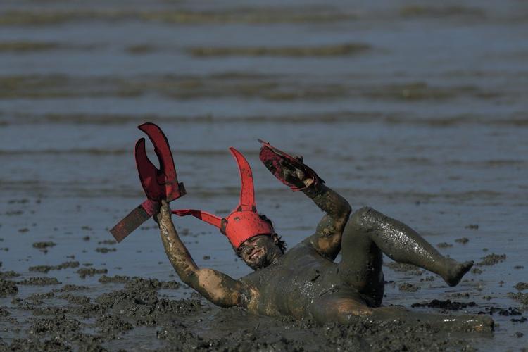 Mud-covered Carnival revelers are a strange sight in sleepy Brazilian town