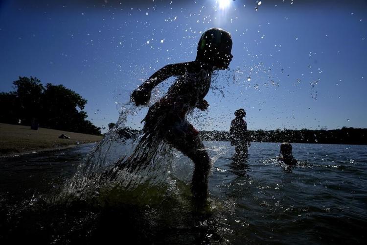 Fair-goers scorched by heartland heat wave take refuge under misters as some schools let out early