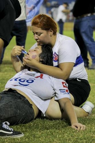 Angry fans crash through gate at El Salvador soccer match in stampede that kills 12, injures dozens