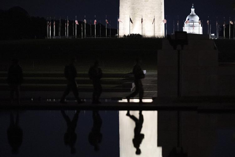 Photos of week three of Washington's federal takeover, as troops on patrol start carrying guns