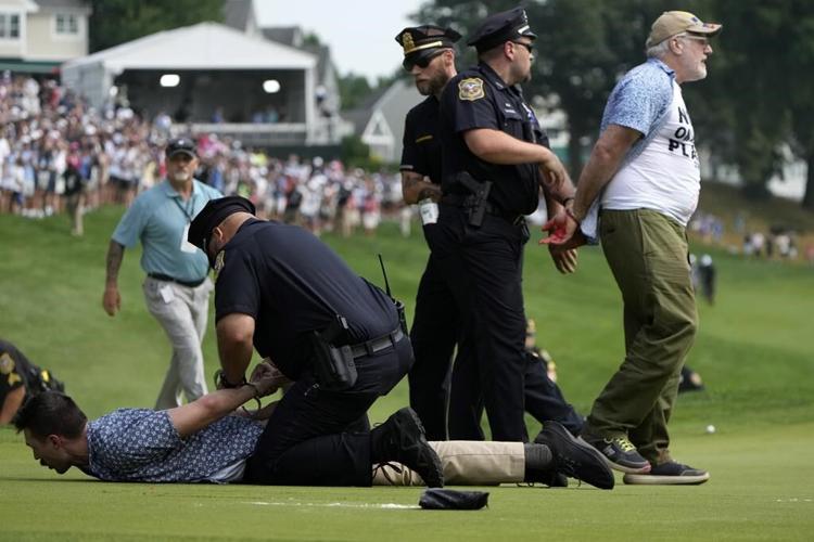 Six climate protesters run onto 18th green and spray powder, delaying finish of PGA Tour event