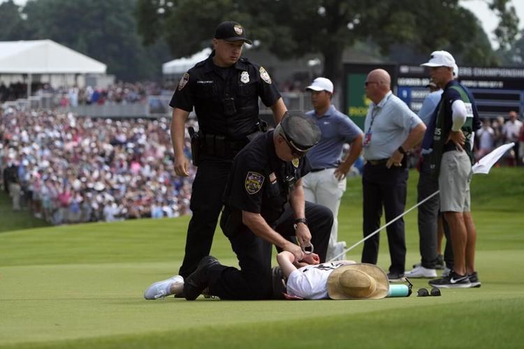 Six climate protesters run onto 18th green and spray powder, delaying finish of PGA Tour event