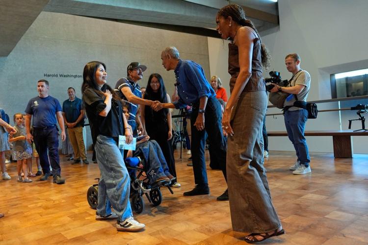 Barack and Michelle Obama surprise first visitors to newly opened presidential center
