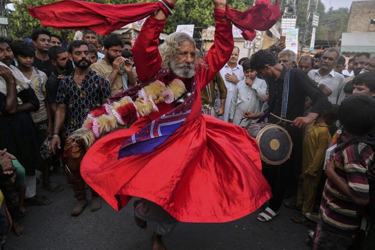 Photos of Pakistan honoring a Sufi saint with drumming, dancing, and bright lights