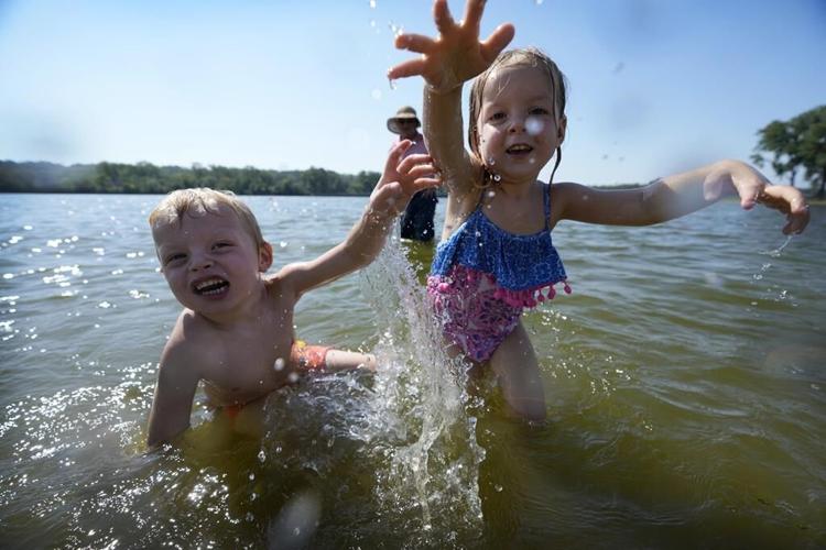 Fair-goers scorched by heartland heat wave take refuge under misters as some schools let out early