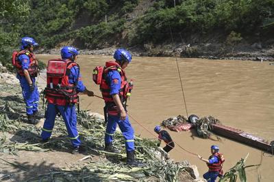Rescuers search for dozens missing after flooding and a bridge collapse in China kill at least 25