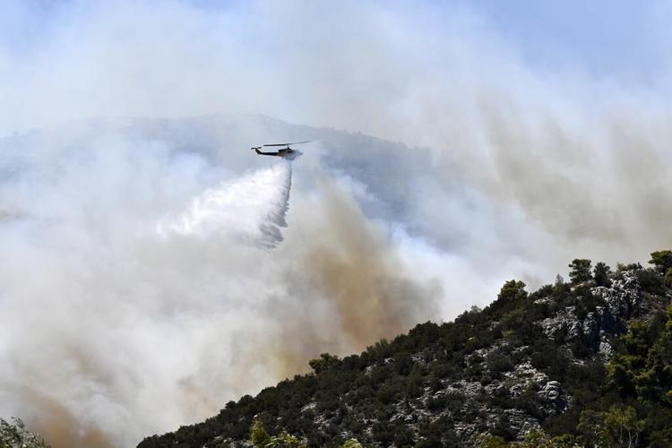 Drop in winds offers hope as firefighters battle huge wildfire on fringes of Athens. 1 person dead