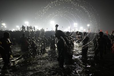 Hindu ascetic rising from the river after a holy dip is emblematic of Maha Kumbh festival in India