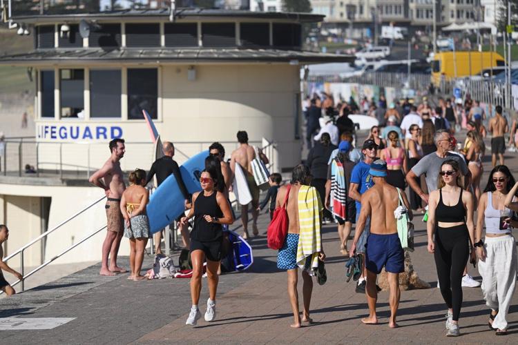 A sunrise crowd gathers at Bondi Beach in solace and defiance after a massacre