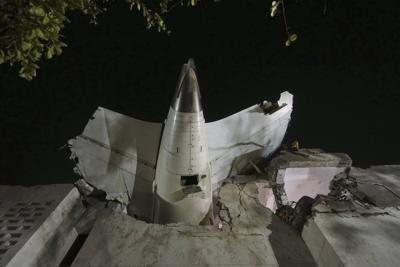 AP PHOTO: Air India plane's tail juts from a building