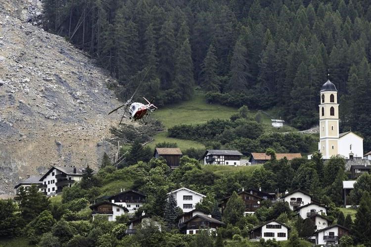 Mass of rock slides down Swiss mountainside above evacuated village, narrowly missing settlement