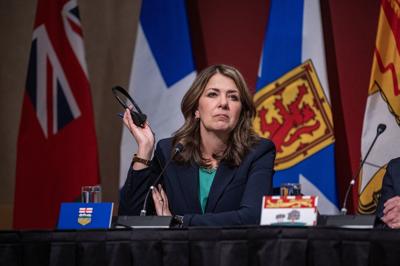 Alberta premier defends charging most Albertans for COVID-19 vaccines