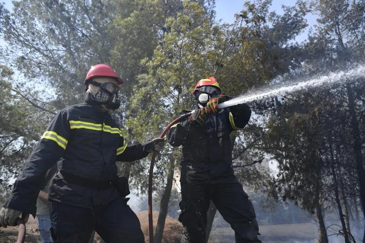 Hundreds of firefighters tackle a major wildfire raging out of control on fringes of Greek capital