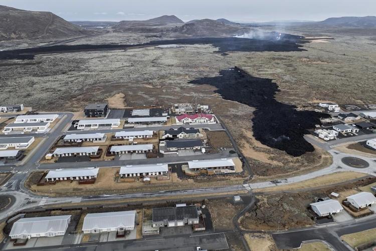 Iceland faces daunting period after lava from volcano destroys homes in fishing town, president says