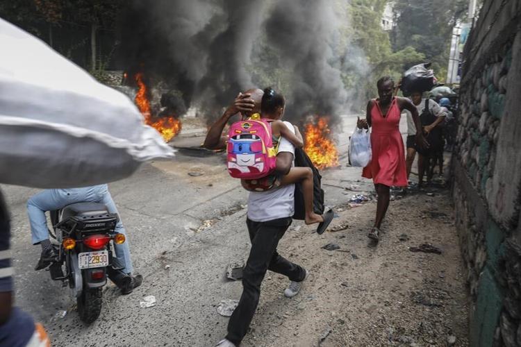 Former rebel leader arrives in Haiti's capital as protests against prime minister gain momentum