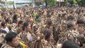 Mud caked devotees wrapped in dried banana leaves honor St. John the Baptist
